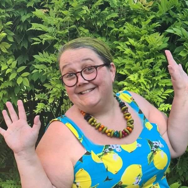 Piece of Cake Web Design Gloucestershire - Amber wearing a turquiose sundress with a lemon pattern and a chunky bead necklace