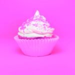 A very pink cupcake with sprinkles