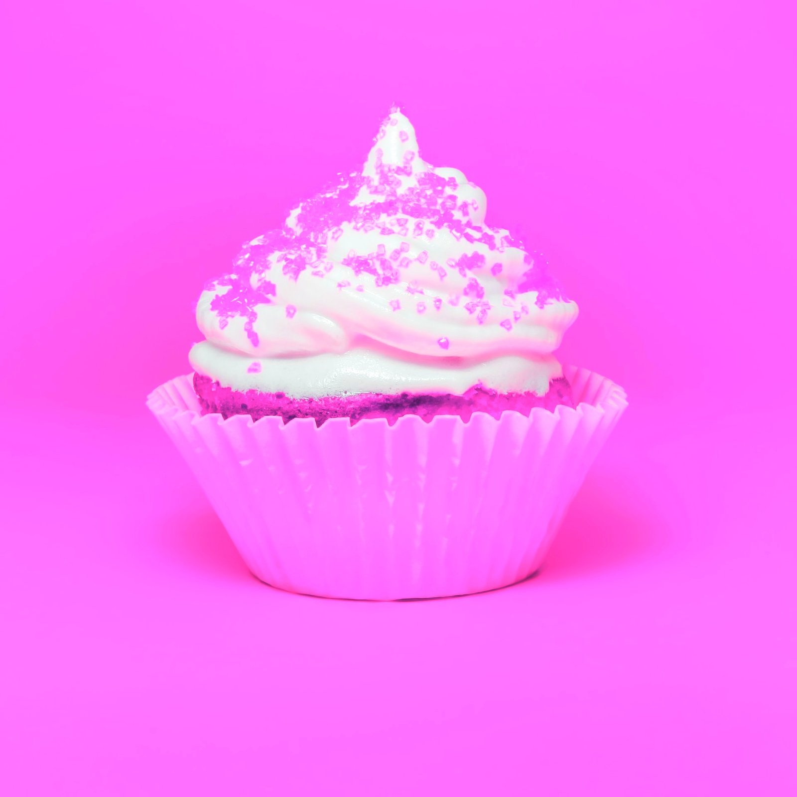 A very pink cupcake with sprinkles